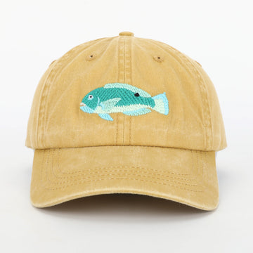 A blackspot tuskfish embroidered on a faded yellow mustard cap.